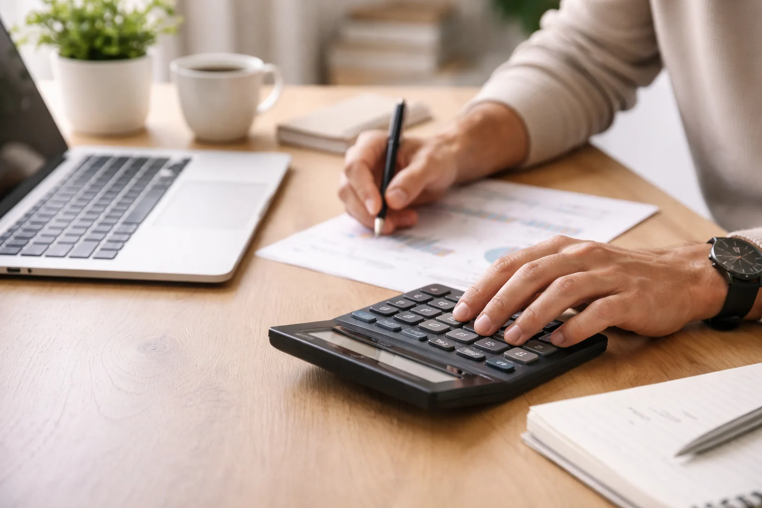 Person calculating marketing numbers at a desk